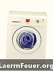 Fjerner toppdekselet til en vaskemaskin